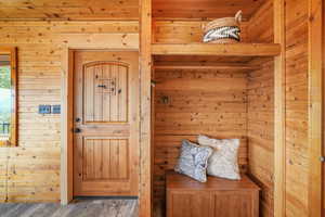 Mudroom with wood walls and wood finished floors