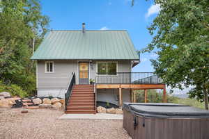 Front of property featuring a hot tub, a metal roof and driveway