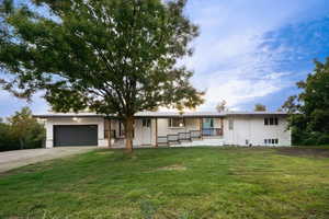 Ranch-style home with a front lawn, concrete driveway, a porch, a garage, and brick siding