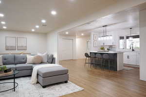 Living room with light wood finished floors and recessed lighting