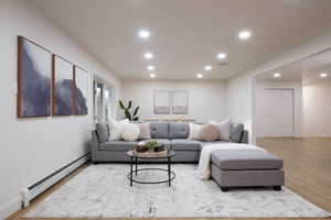 Living area featuring baseboard heating, light wood-style flooring, and recessed lighting