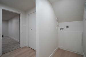 Laundry room with light wood-style flooring, hookup for a washing machine, and electric dryer hookup