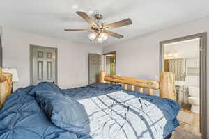 Bedroom with wood finished floors, a ceiling fan, a closet, and connected bathroom