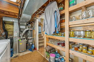 Utility room with heating unit, water heater, and washing machine and clothes dryer