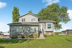 View of front facade featuring brick siding and roof with shingles