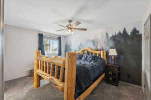 Carpeted bedroom with a closet and ceiling fan