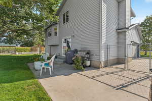 View of side of home featuring a gate and a patio