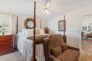 Bedroom with ceiling fan and light colored carpet