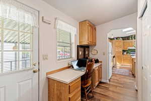 Office with light wood finished floors and arched walkways