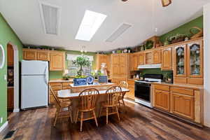 Kitchen with white appliances, light countertops, a breakfast bar, and a kitchen island