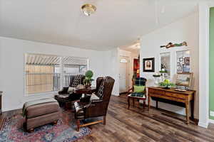 Sitting room featuring dark wood-style flooring and baseboards