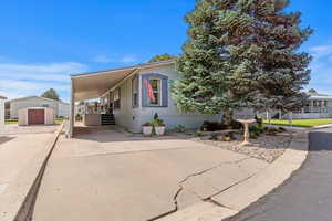 Manufactured / mobile home with concrete driveway and a carport