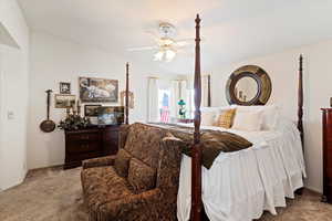 Bedroom featuring carpet floors, lofted ceiling, and a ceiling fan