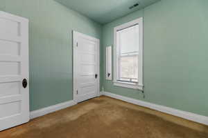 Carpeted spare room with baseboards