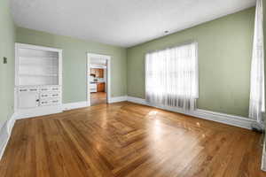 Empty room featuring a textured ceiling and wood finished floors