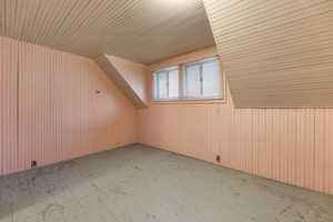 Bonus room featuring wood walls, wood ceiling, and lofted ceiling