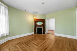 Unfurnished living room with a fireplace, a textured ceiling, and baseboard heating