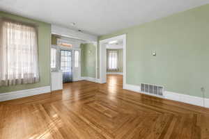Empty room with a textured ceiling and baseboards