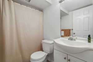Full bath with vanity, a textured wall, and a shower with shower curtain
