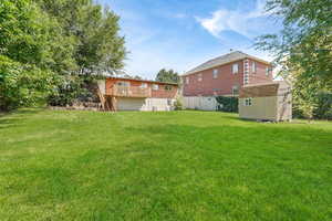 View of yard with a storage unit, a wooden deck, and stairway