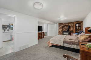 Family room being used as a bedroom with carpet flooring, a wood stove, and a textured ceiling