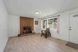 Living room with light wood-style flooring and a fireplace