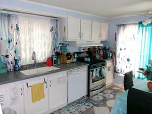 Kitchen featuring white cabinetry, stainless steel gas range oven, dark countertops, and dishwasher