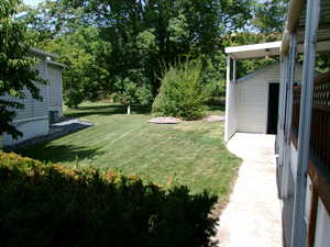 View of green lawn featuring view of scattered trees