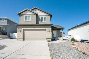 Traditional-style house with stone siding, stucco siding, driveway, and a porch