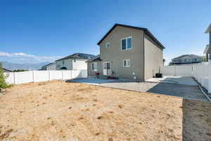 Rear view of property with a patio area, a fenced backyard, and stucco siding
