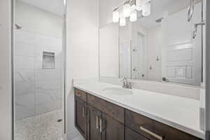 Bathroom with vanity and a tile shower