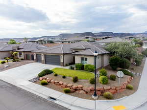 Prairie-style house featuring a garage, a residential view, driveway, and stucco siding