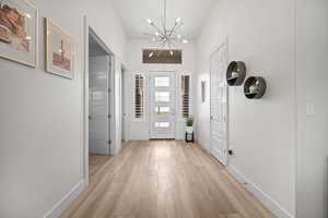 Foyer entrance featuring light wood finished floors and a chandelier