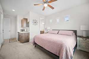 Bedroom with light carpet, recessed lighting, connected bathroom, and a ceiling fan