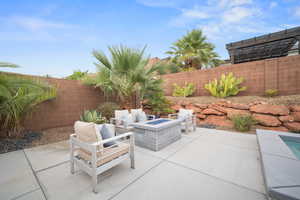 Fenced backyard with a patio and a fire pit