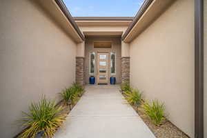 Entrance to property featuring stucco siding and stone siding
