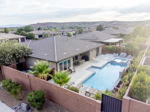 View of pool with a patio area, a fenced backyard, a pool with connected hot tub, a residential view, and a mountain view
