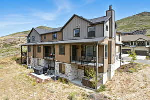 View of front of property with roof with shingles, board and batten siding, a mountain view, and a chimney