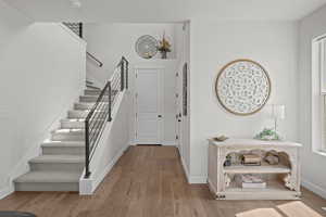 Foyer entrance with stairway and light wood-style floors