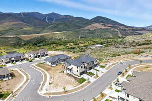 Aerial view of property and surrounding area with mountains and nearby suburban area