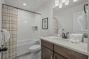 Bathroom featuring shower / tub combo, vanity, light tile patterned flooring, and recessed lighting