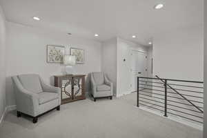Sitting room featuring an upstairs landing, carpet flooring, and recessed lighting