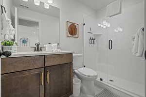 Bathroom with vanity, a shower stall, and light tile patterned floors