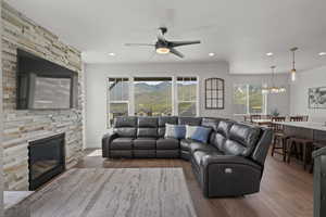 Living area with hardwood / wood-style floors, a fireplace, ceiling fan, and recessed lighting