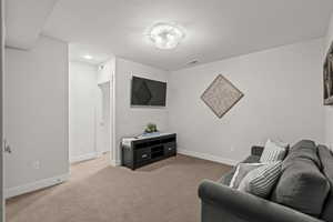 Living area featuring carpet floors and baseboards