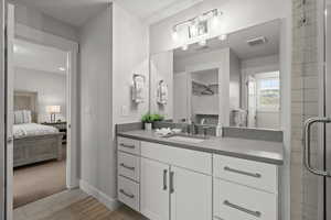 Ensuite bathroom featuring vanity, a shower stall, and light tile patterned flooring