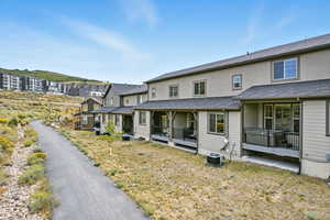 Back of house with stucco siding and a wooden deck