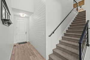 Stairway featuring wooden walls and wood finished floors