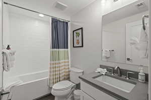 Full bathroom with shower / bath combo, vanity, and recessed lighting
