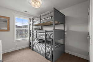 Bedroom featuring light carpet